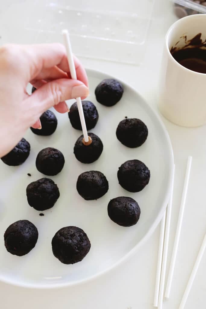 putting sticks into chocolate cake pops