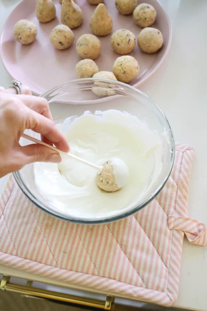 dipping cake pops into melted chocolate for christmas cake pops