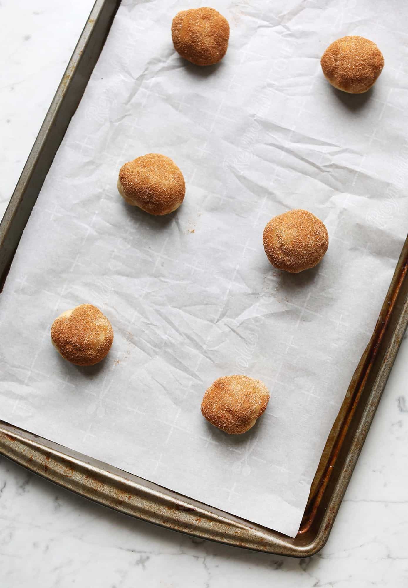 rolled balls of snickerdoodles on baking pan